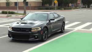 Dodge Charger negro en carril peatonal.