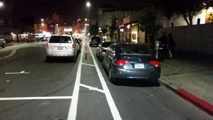Aparcamiento en el carril bici por falta de señalización y delimitadores verticales (Fuente: Scott Morris)
