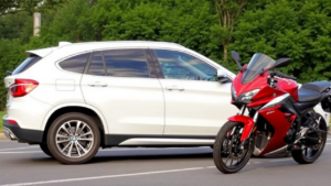 a red motorcycle parked next to a white car