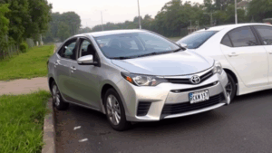 Silver Toyota Corolla parked near road.