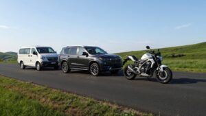 Van, SUV, and motorcycle on road.