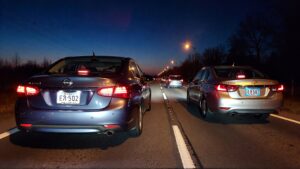 Dos sedanes circulando por la autopista de noche.
