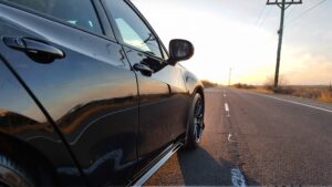 Black Acura sedan on empty road