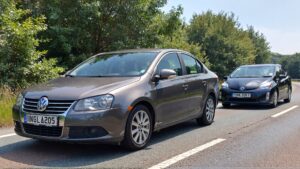 Gray Jetta and black Prius parked.