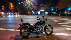 Motorcycle parked at night intersection.