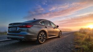Gray sedan on roadside at dawn.