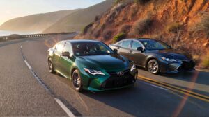 Two Toyotas driving along coastal road