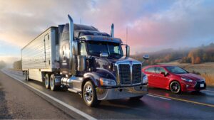Semi-truck and red Prius on road