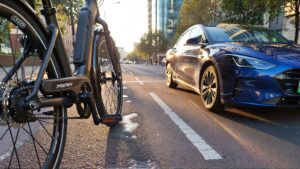 E-bike and car on urban road.