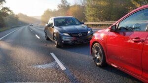 Gray Acura and red Volkswagen on road