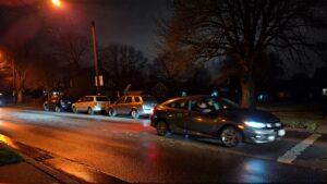 Night scene with parked cars.