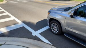 Silver SUV at crosswalk intersection.