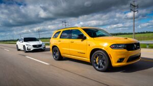 Yellow SUV and white sedan driving