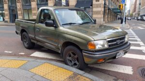 Green Toyota truck on pedestrian lane.