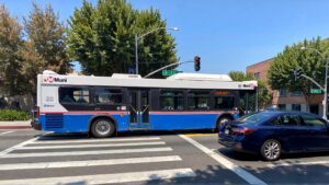 Muni bus crossing intersection with car
