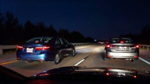 Two cars on highway at night.