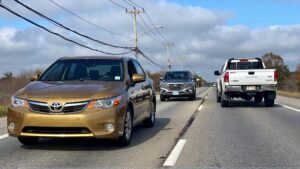 Three cars driving on a highway.