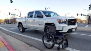 White truck near wheelchair on street