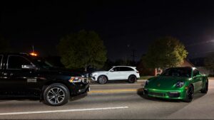 Three luxury vehicles at night.