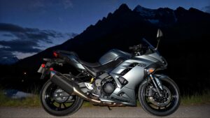 Gray motorcycle beside mountains at night