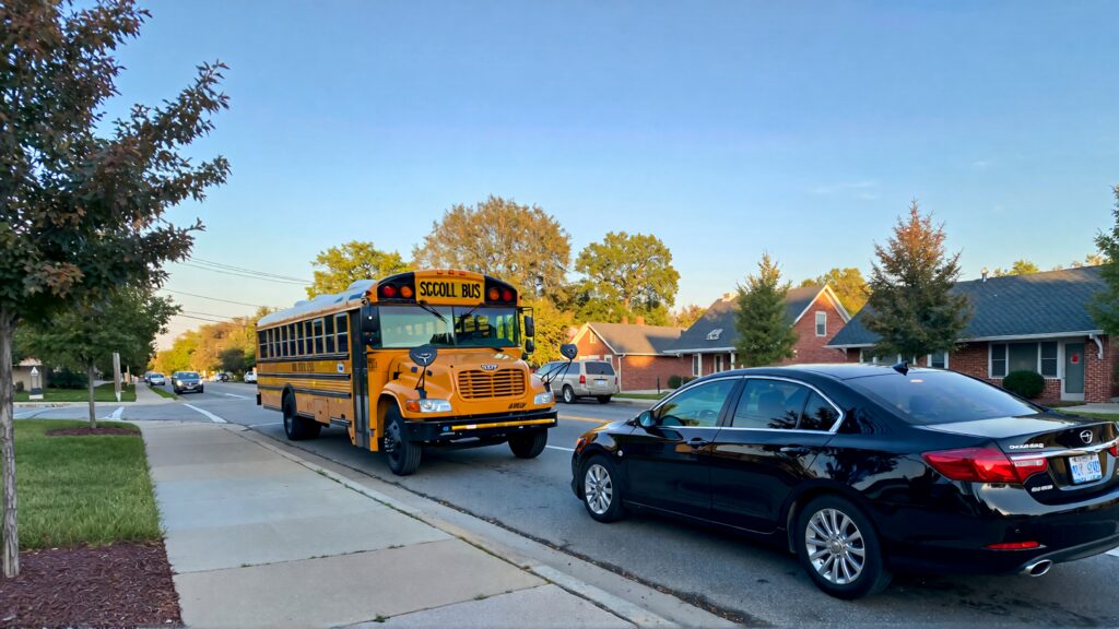 Juris digital a school bus and a black sedan on the street in the morning 893da988 1a04 4b73 b393 4f6cac9fcd86