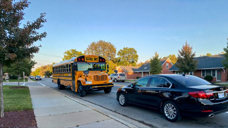 Juris digital a school bus and a black sedan on the street in the morning 893da988 1a04 4b73 b393 4f6cac9fcd86