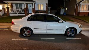 White Volkswagen Passat parked at night.