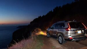 SUV parked near cliff at dusk