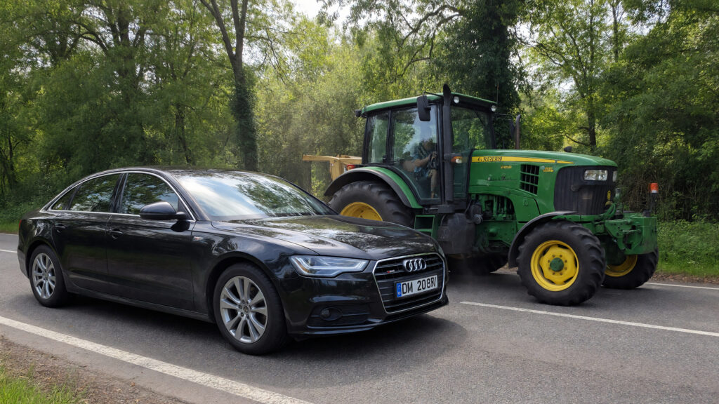 Samantha parian An Audi sedan and a slow moving John Deere farm tractor on the ro 54f61d5c 5132 4e76 824b 2e954619390a