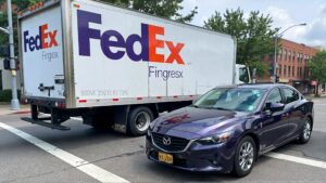 FedEx truck and Mazda sedan intersection