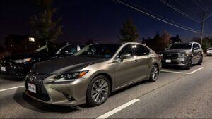 Three cars parked at dusk.