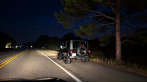 Jeep parked on dark highway.