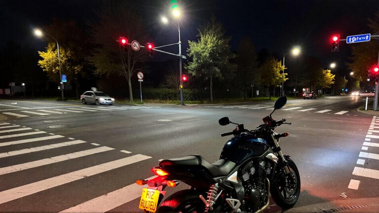 Motorcycle parked at night intersection.