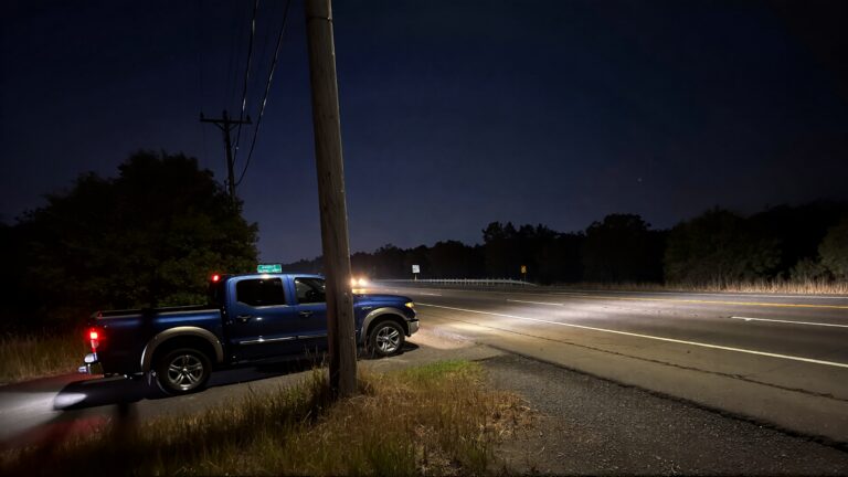 Truck parked on dark highway at night.