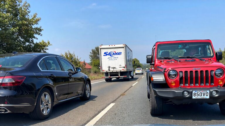 Red Jeep, black sedan, box truck.