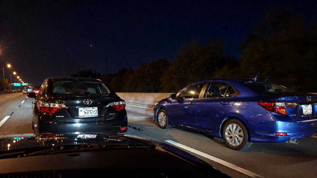 Samantha parian A black Toyota Corolla and a blue Honda sedan in the highway at n 708bffad 170a 45fe 9a7c d41a6f896161