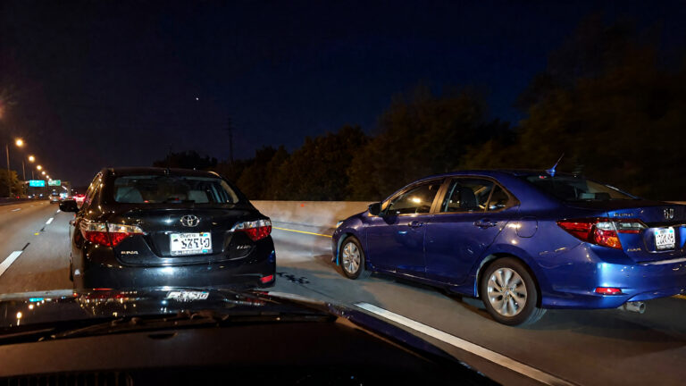 Two cars on a highway at night.