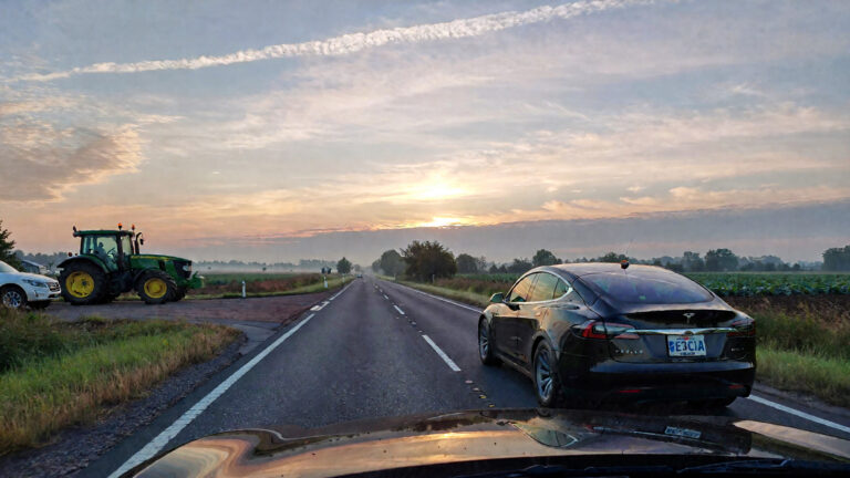 Tesla and tractor on rural road