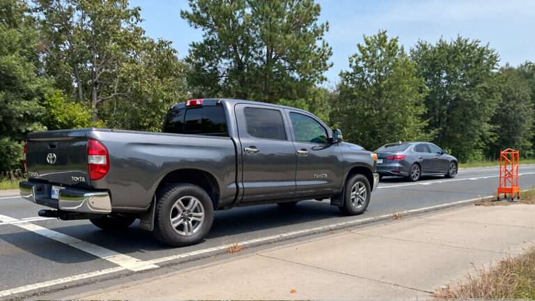 Grey truck and sedan on road