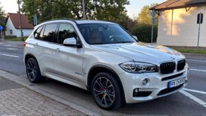 White BMW SUV parked on street.