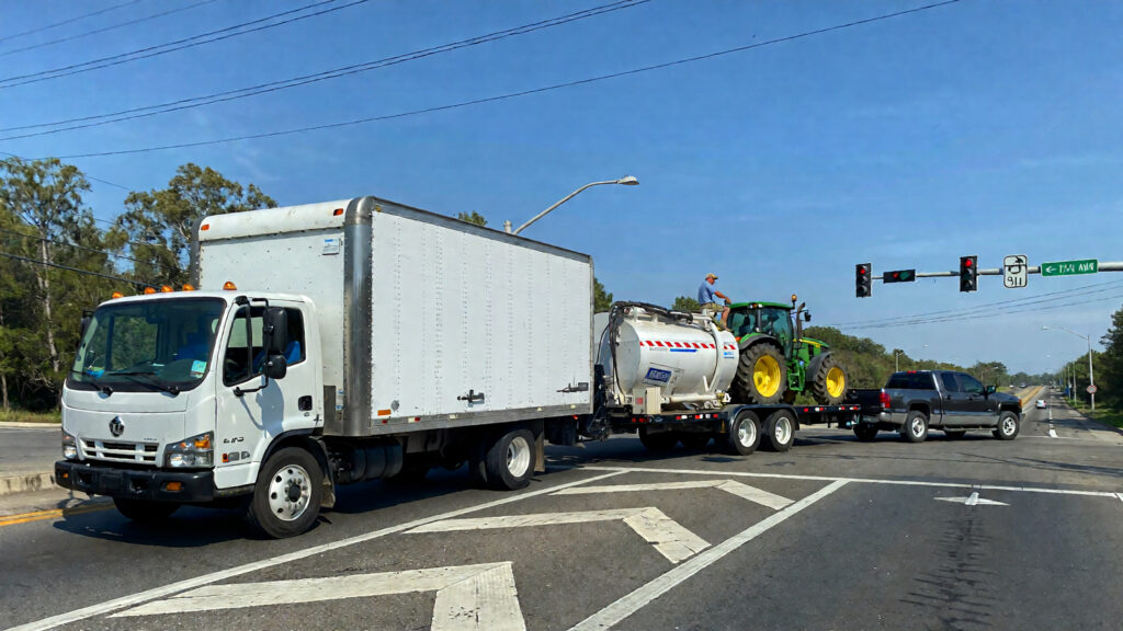 Samantha parian a white box truck a pickup truck towing a trailer loaded with a 01062b81 3e21 4dc9 af68 0ccfc368022a