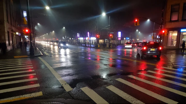 Calle mojada con semáforos encendidos