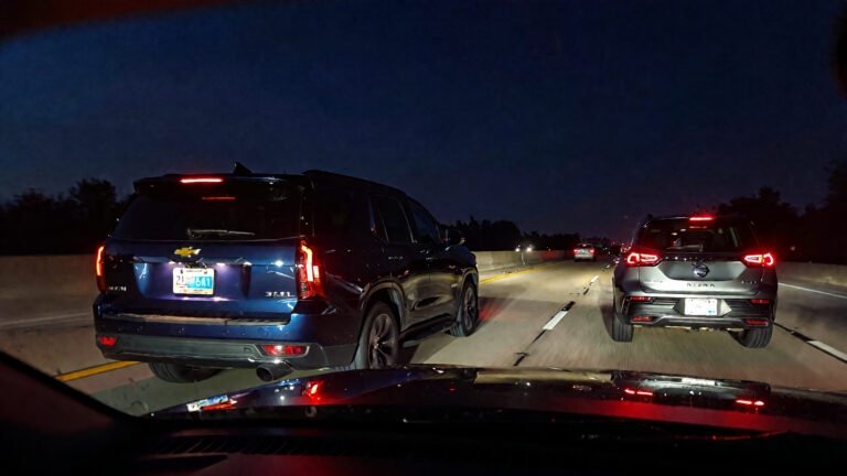 Two SUVs on a nighttime freeway.