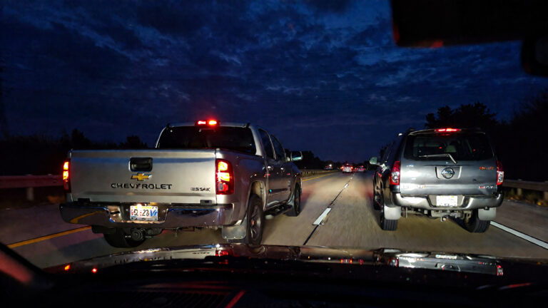 Two vehicles on a dark highway.