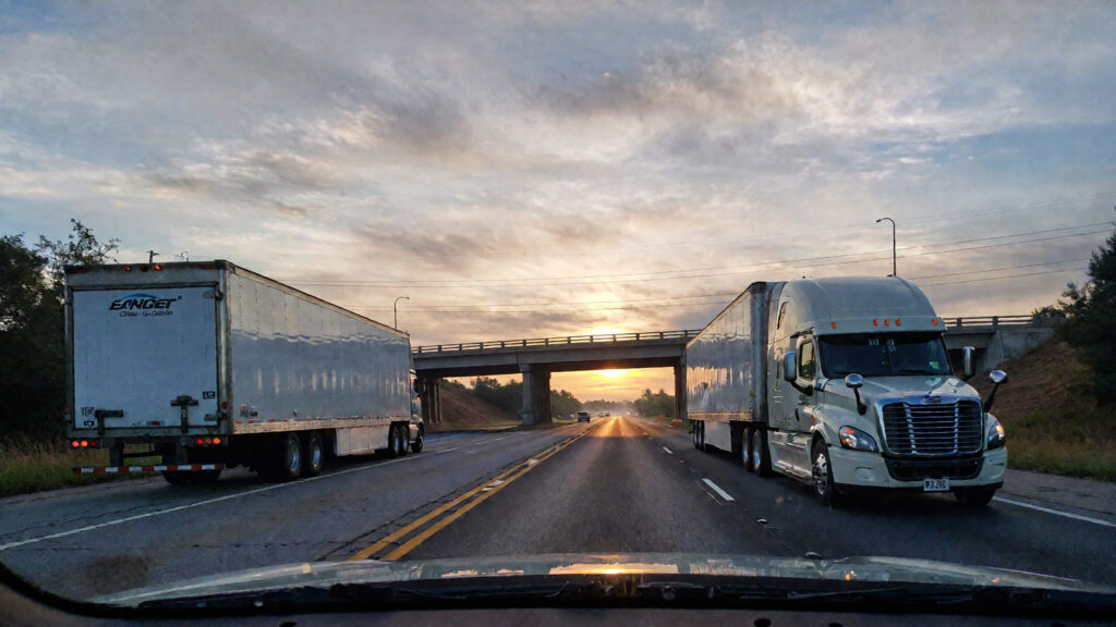 Samantha parian a semi truck and a utility trailer on the road near the bridge at 75cb4b22 889a 41ef 8aeb ded14a5c7e65