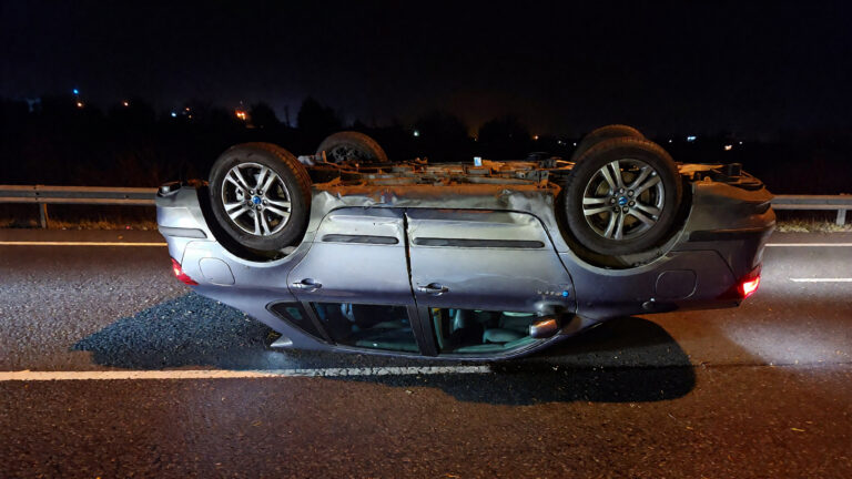 Auto volcado en una carretera oscura.