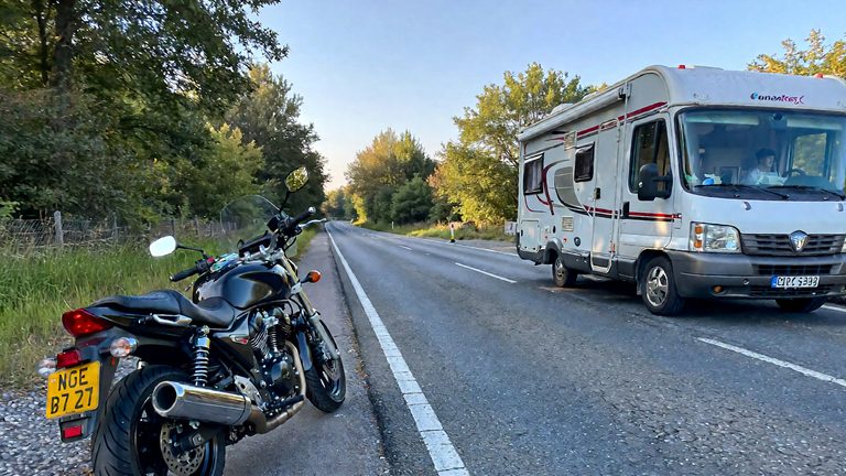 Motocicleta y casa rodante a un lado de la carretera