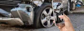 A person taking a photo of a car accident